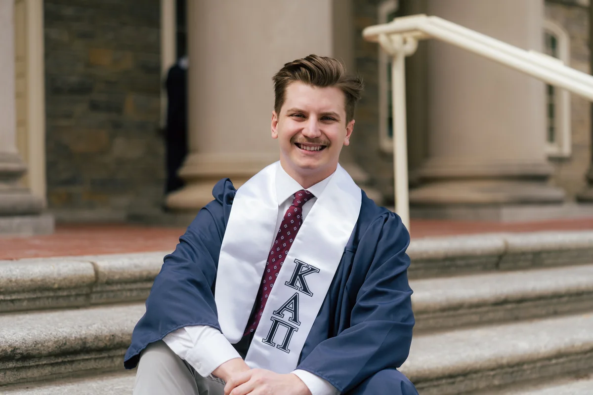 Graduate seated on broad stone steps